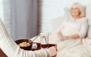 Lady bringing breakfast to elderly