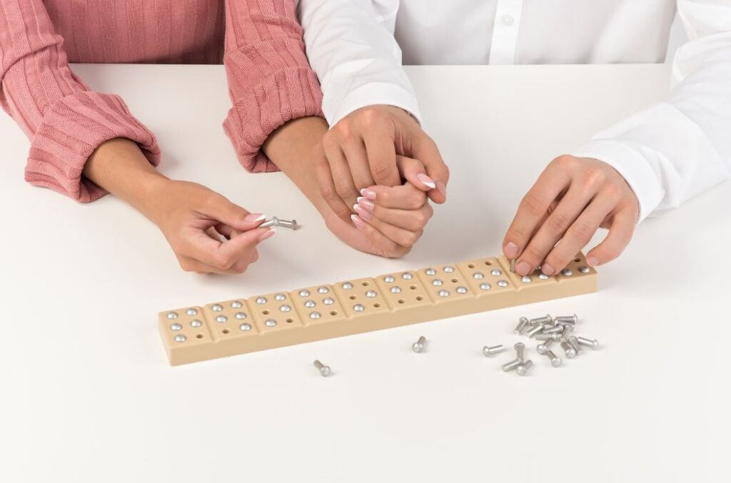 two people learning braille