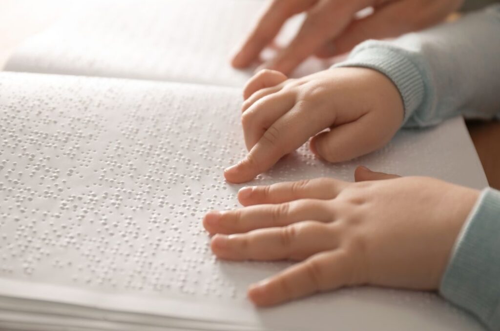 mum helping child to read a braille book