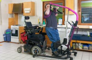 man with hoist and wheelchair