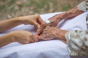 person holding elderly persons hands