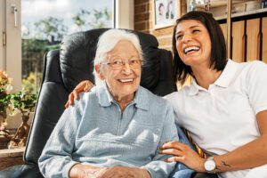 A live in carer is smiling alongside the person they are looking after