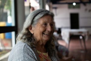 Smiling elderly woman in grey cardigan