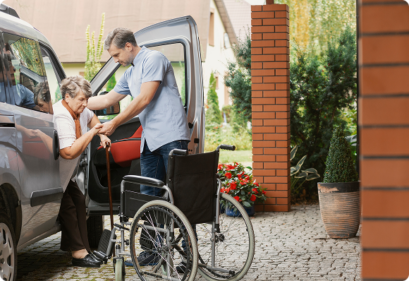 A woman assists a man in a wheelchair, demonstrating support and collaboration in a caring environment