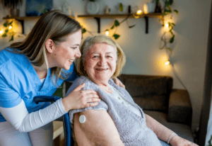 A nurse assists a woman in a wheelchair, providing support and care in a healthcare setting