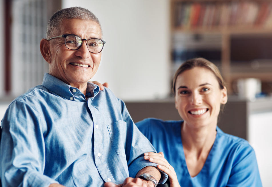 A smiling man and woman sit together in a chair, exuding warmth and friendliness
