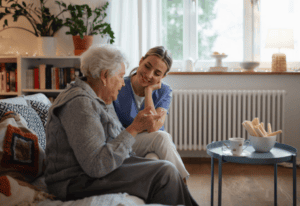 A woman converses with an older woman while seated on a couch, sharing a moment of connection and engagement
