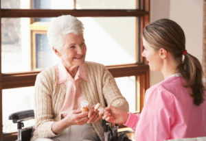 A woman in a wheelchair engages in conversation with a nurse in a healthcare setting